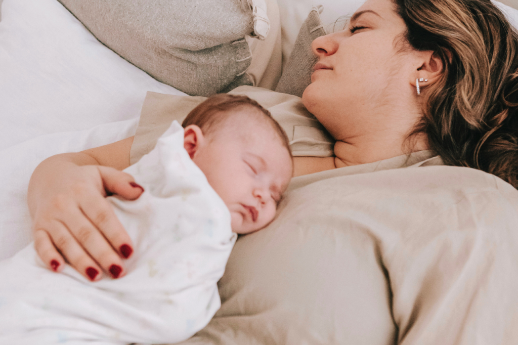 maman et bébé endormis dans les bras l'un de l'autre